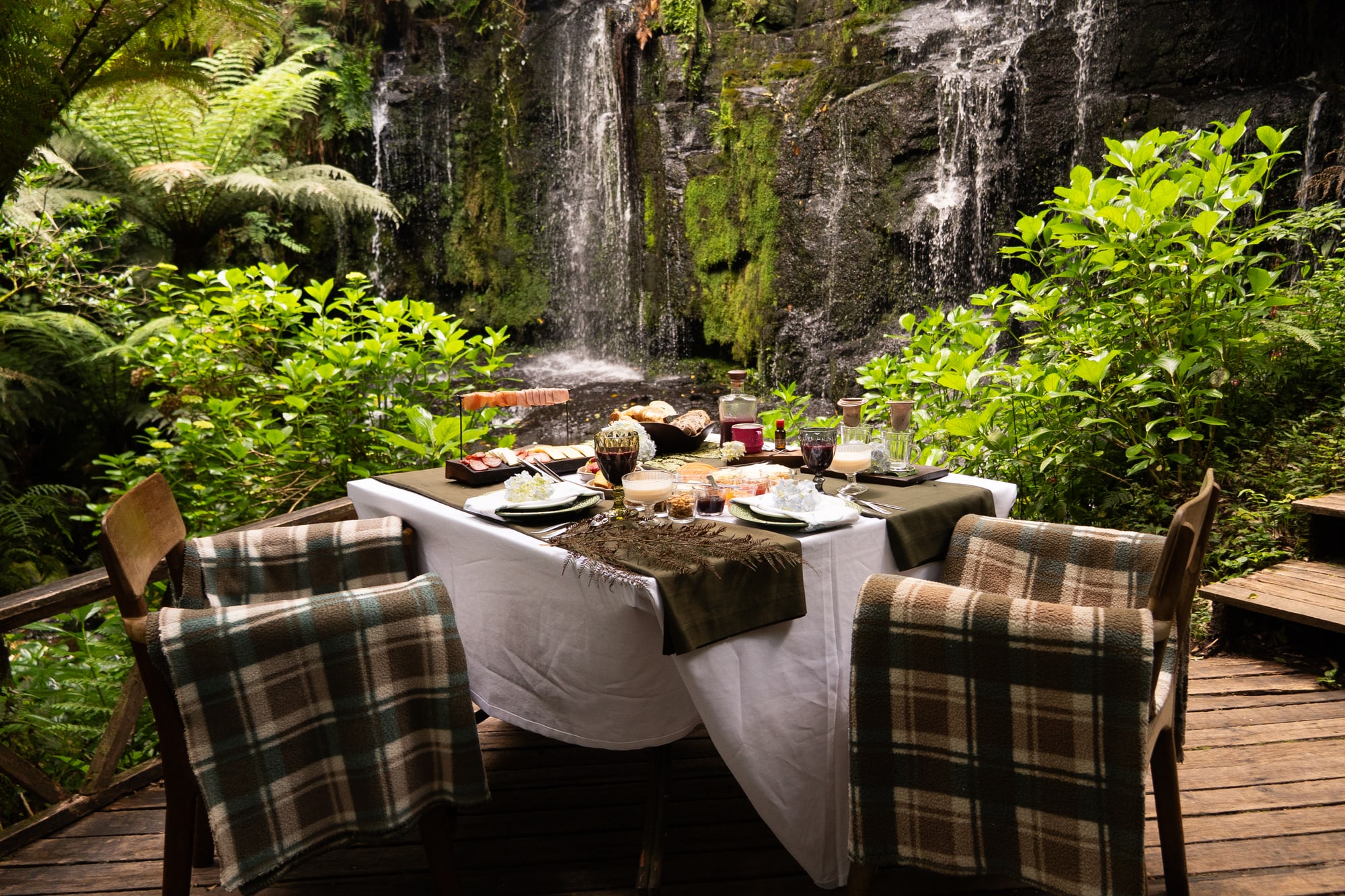 A mesa do Café na Cachoeira posta no deque, com a queda d'água ao fundo