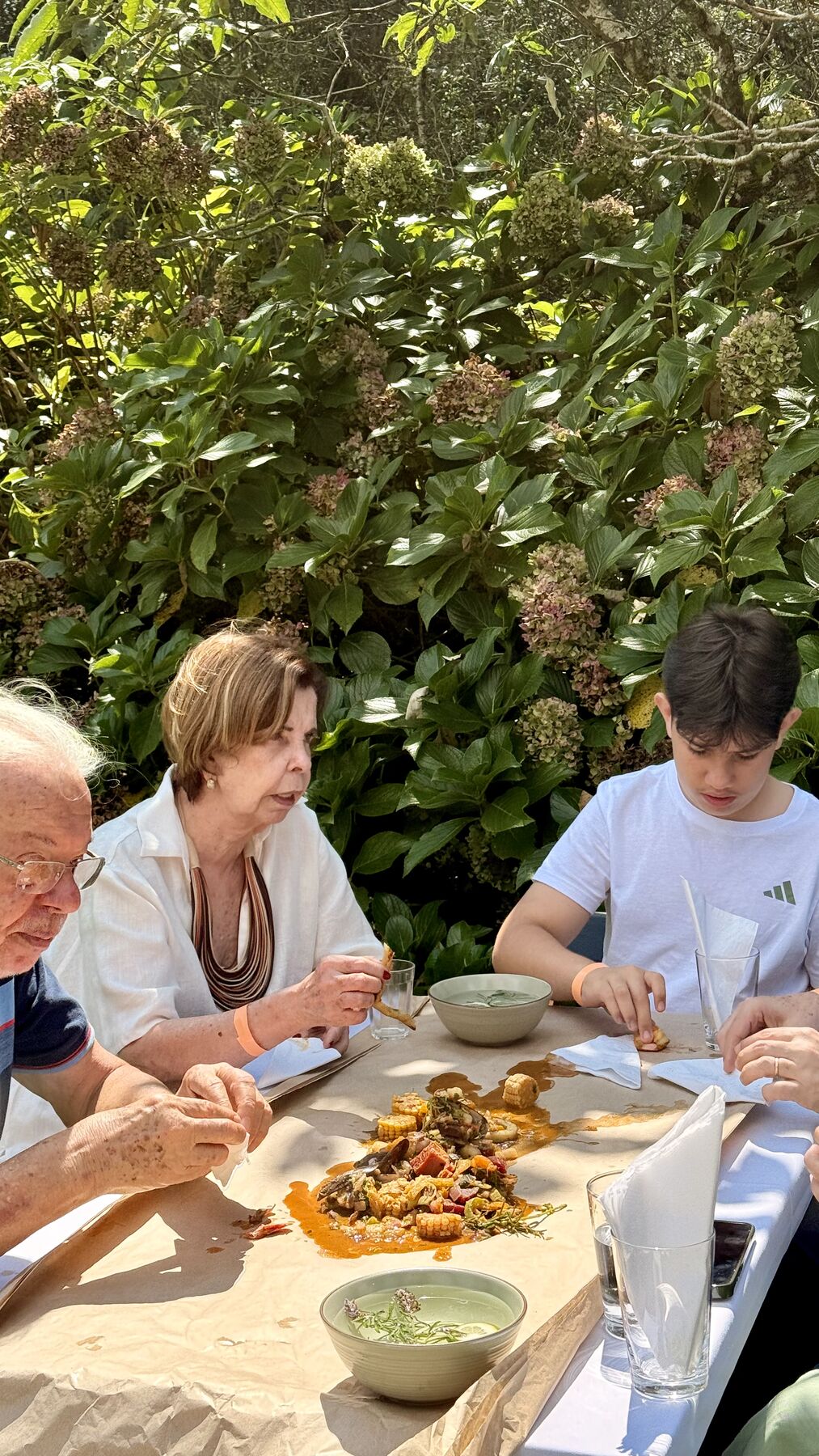 Convidados comendo com as mãos na mesa coberta de papel