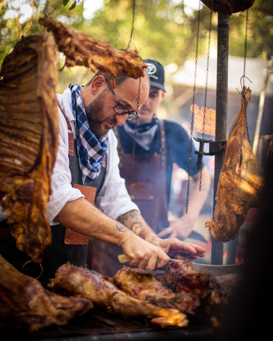 O chef e a equipe cortando as carnes do fogo