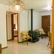 Sala com lareira, poltronas e luminária de galhos