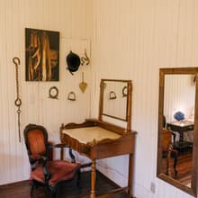 Penteadeira antiga e objetos campeiros na parede